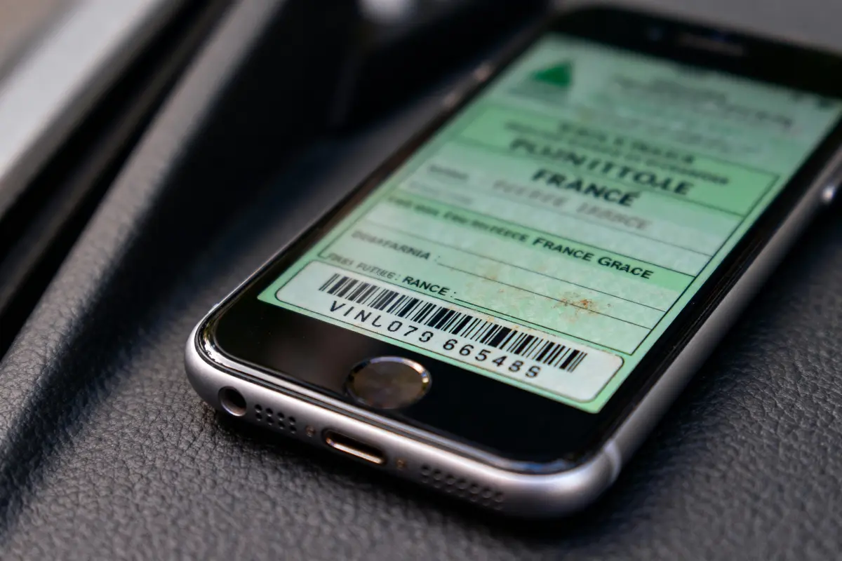 Téléphone affichant un ticket avec un code-barres et des informations textuelles. Fond en cuir noir.