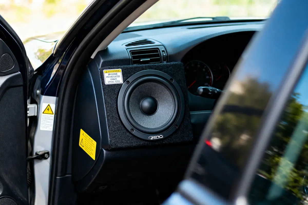 Haut-parleur monté dans une voiture, à côté du volant, sur le tableau de bord.