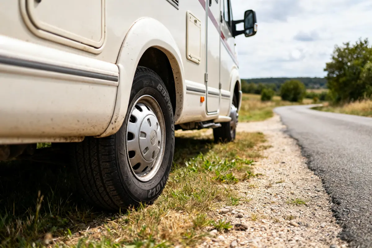 Camping-car stationné avec pneu camping car 215 70 r15 cp sur route de campagne