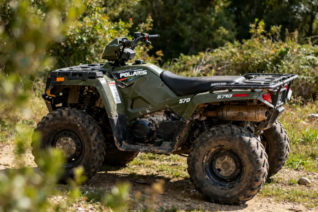 Quad Polaris Sportsman 570 stationné en extérieur, montre des signes de problème potentiel.
