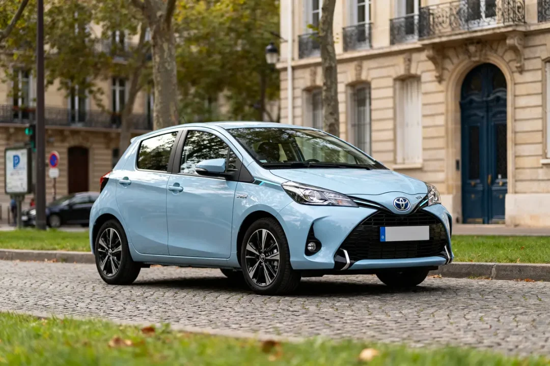 Toyota Yaris hybride automatique bleue garée devant un immeuble parisien élégant