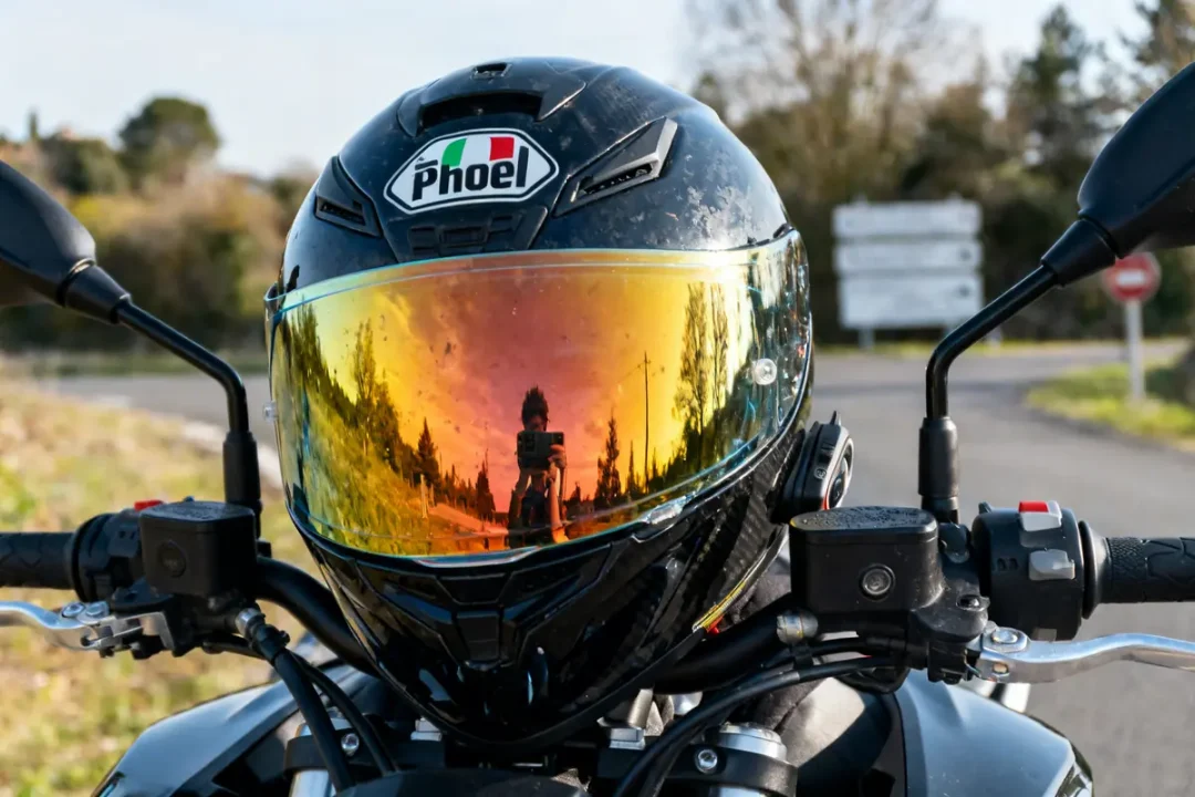Casque de moto avec visière iridium homologuée reflétant un paysage arboré en arrière-plan