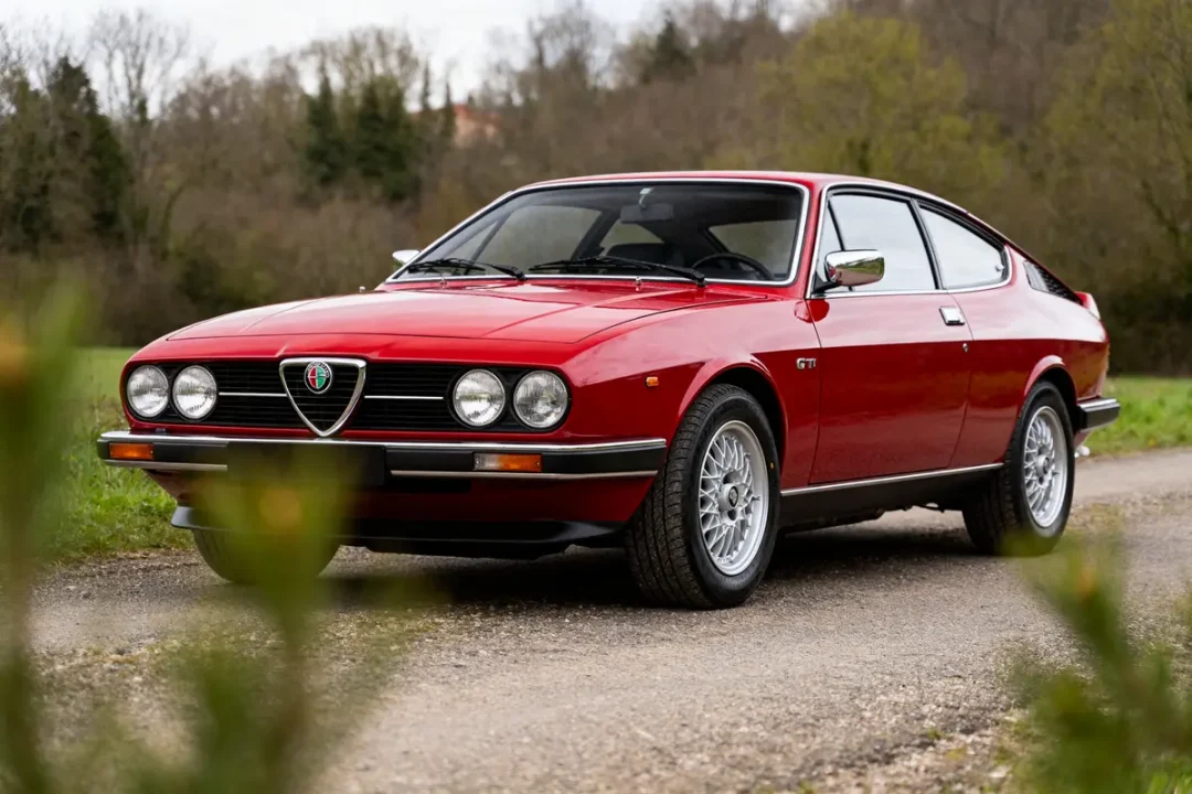 Voiture rouge classique Alfa GTV 6 sur route de campagne bucolique