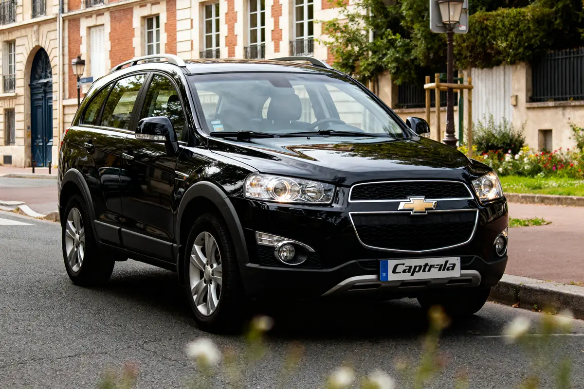 SUV noir Chevrolet Captiva automatique garé en ville sur une chaussée.