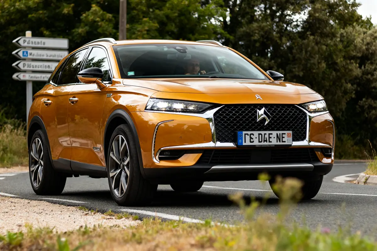 SUV Citroën DS7 Crossback doré roulant sur route sinueuse en pleine campagne