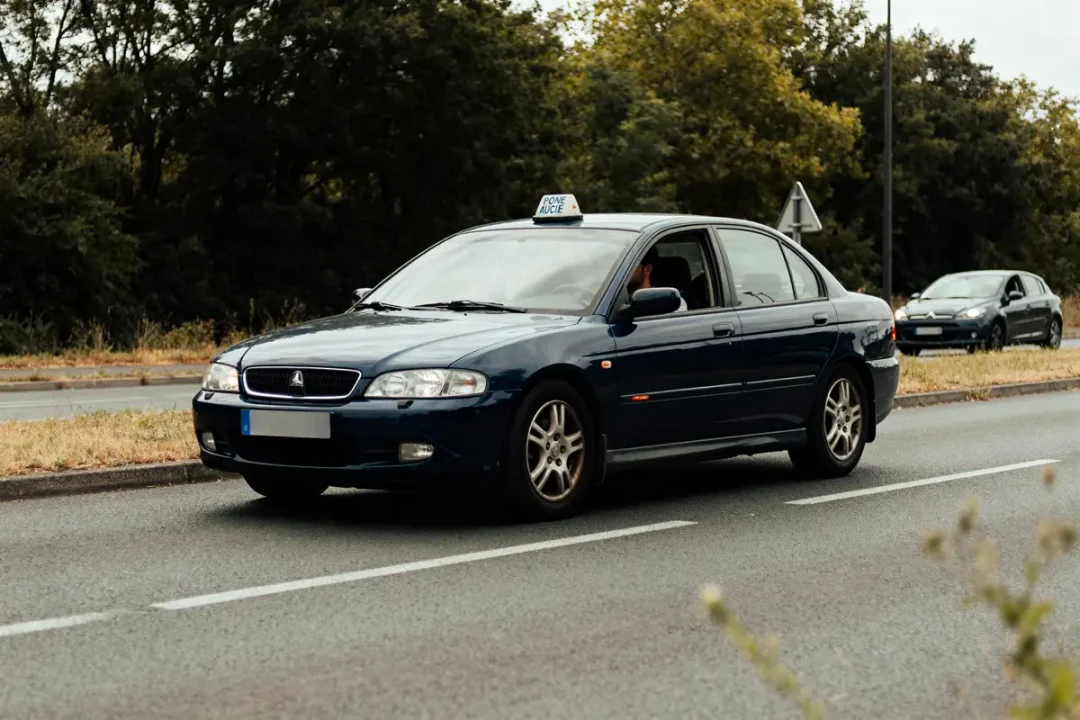 Voiture d’auto-école sur la route illustrant conduite sans permis récidive trois fois