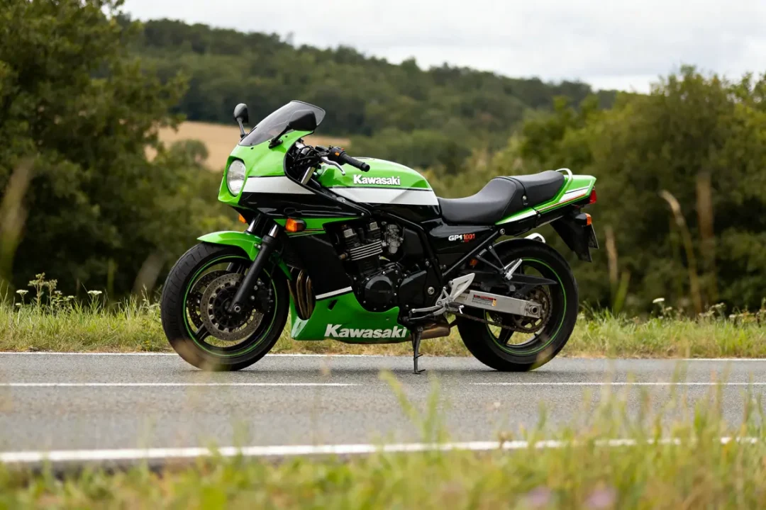 Moto Kawasaki GPZ 1000 RX verte stationnée sur une route de campagne.