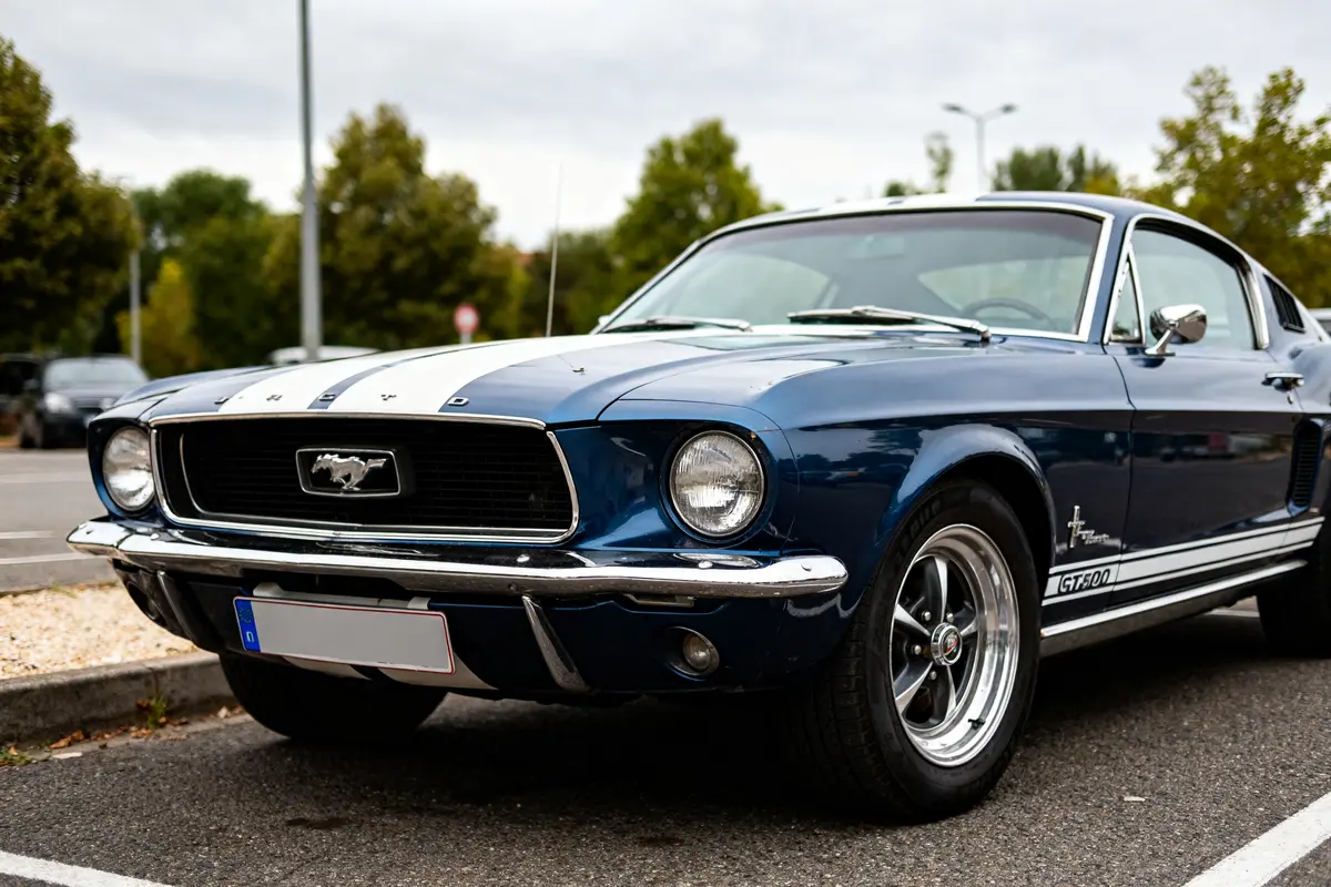 Voiture classique bleu sur stationnement : Ford Mustang GT500 de 1967.